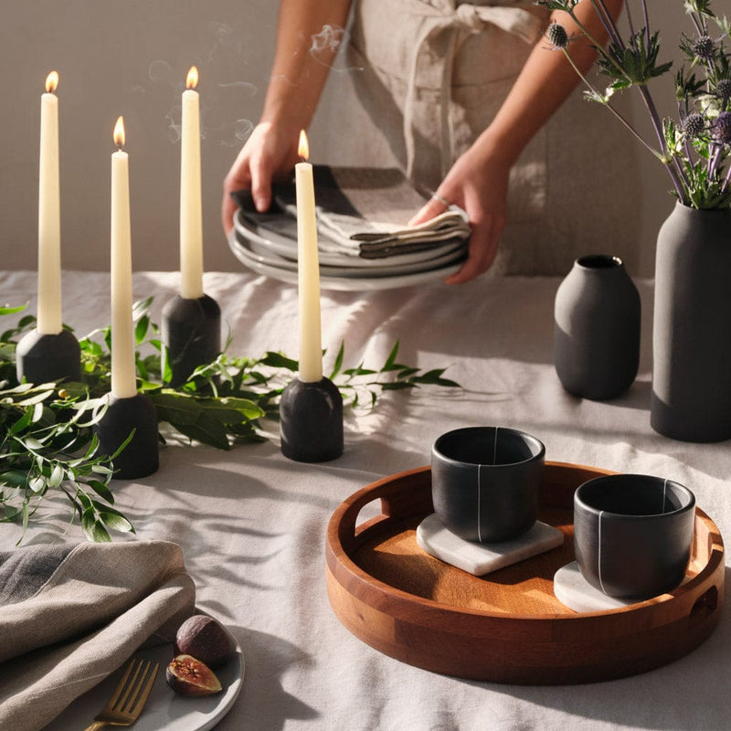 Black clay cups styled on tabletop with marble accents, black