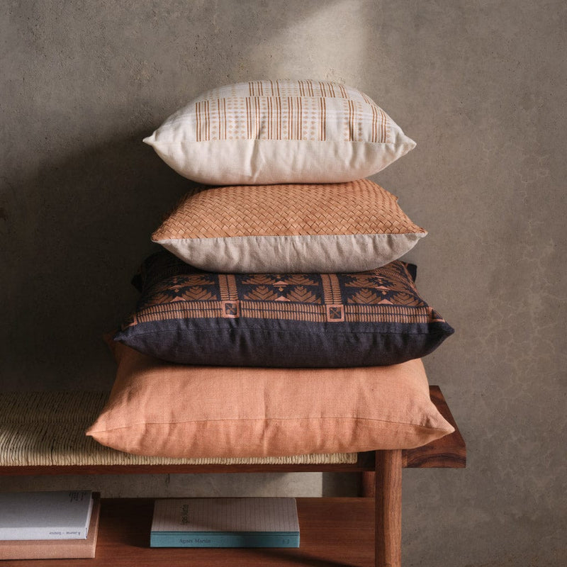 Stack of linen and leather and block print pillows, clay