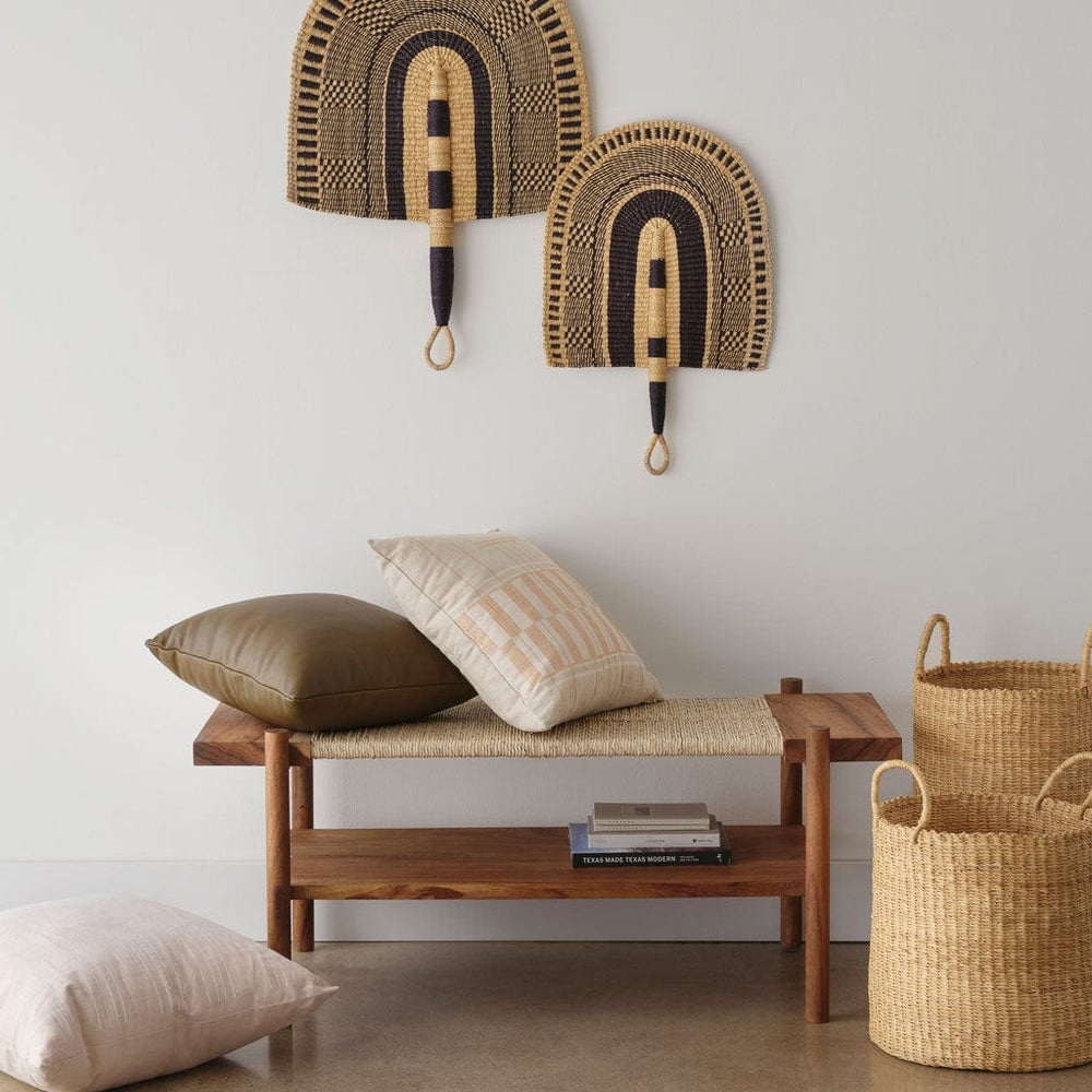 Pillows and baskets styled near wooden bench