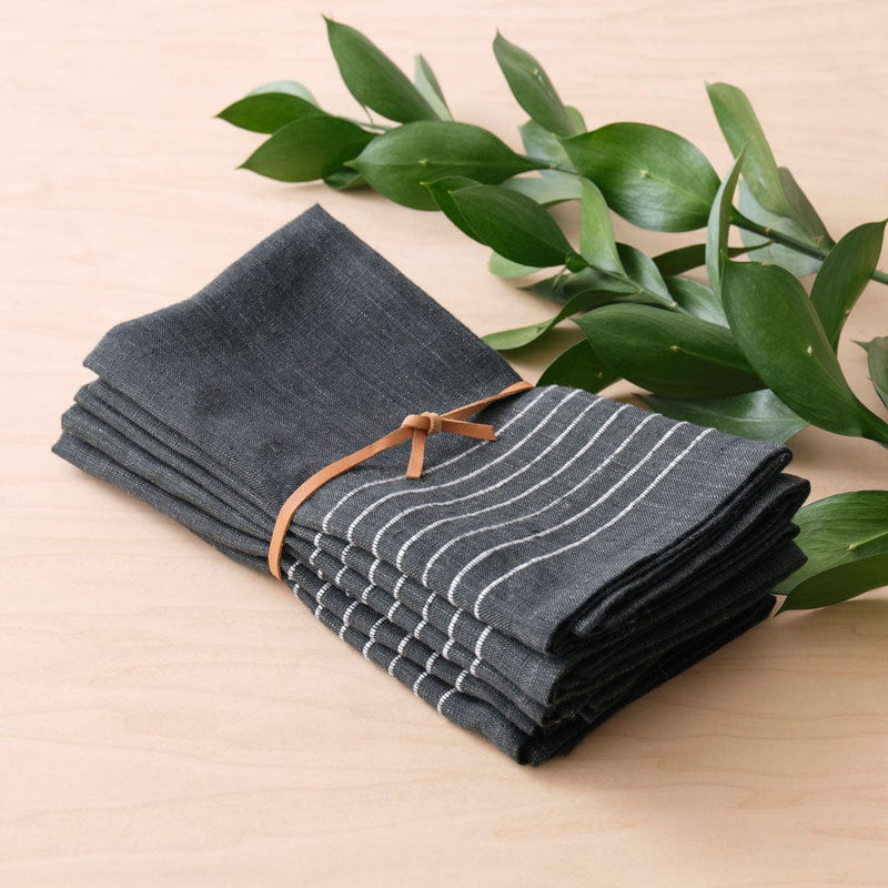 Folded napkins bundled by leather tie, charcoal