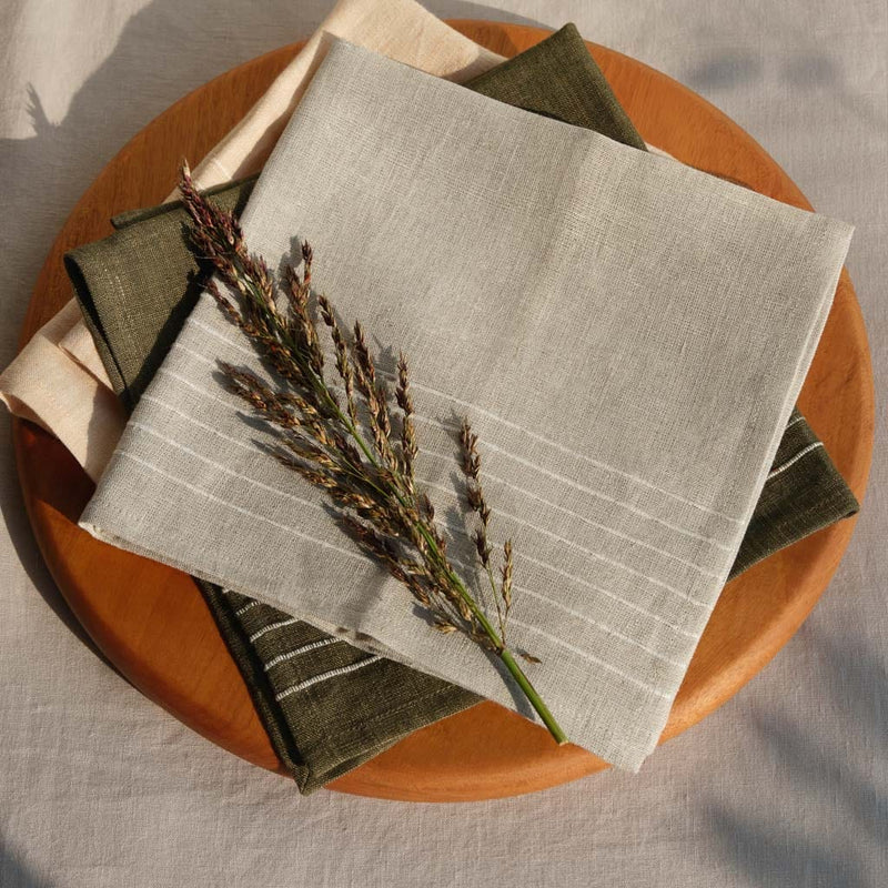 Folded linen napkins on wooden cutting board, flax
