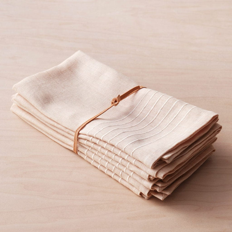 Folded napkins bundled with leather tie, rose