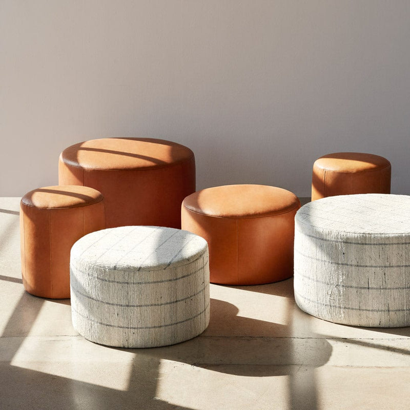 Collection of cotton and leather ottomans in varying sizes, stripe