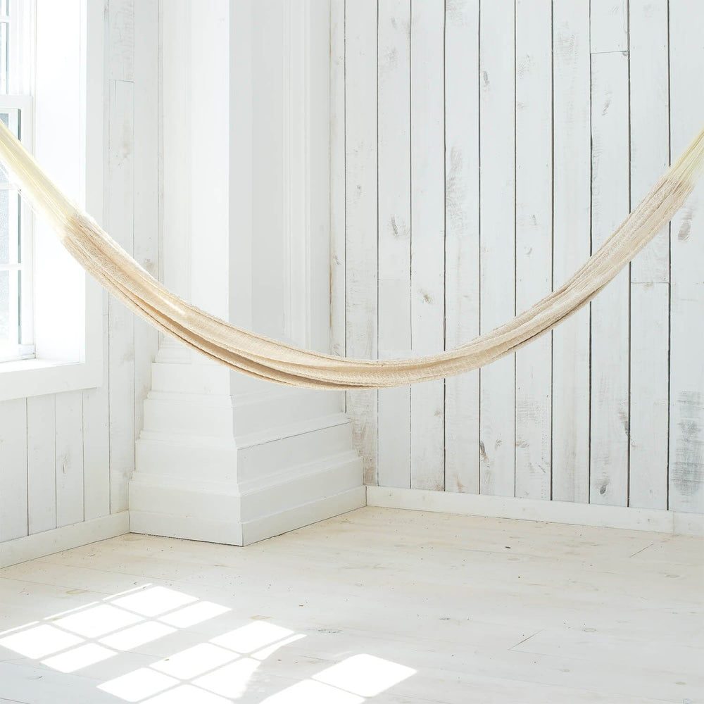 Woven hammock hanging in open room