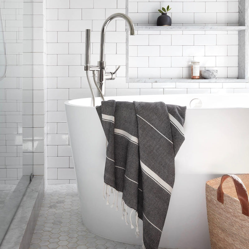 Towel hanging on modern bathtub edge, black