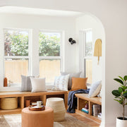 boucle pillow styled on window bench with leather ottomans, sand