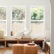 boucle pillow styled on window bench with leather ottomans, sand