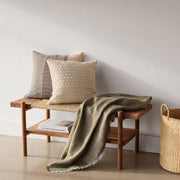 boucle pillow styled on bench, sand