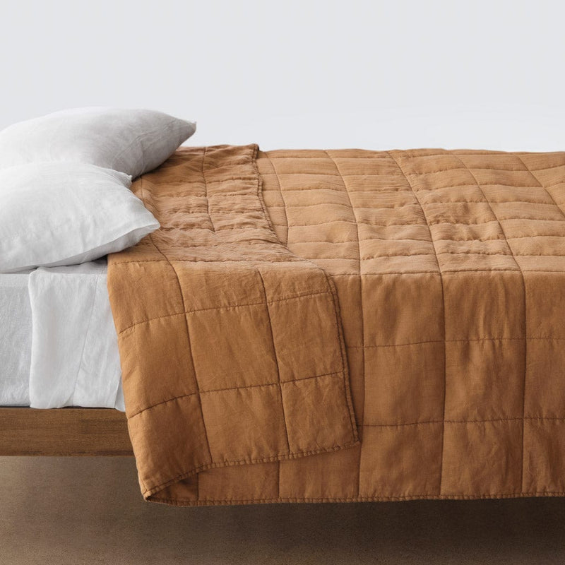 Side of bed with camel stonewashed linen quilt, camel