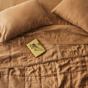Overhead of camel linen quilt and sheet set, camel