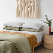 Camel linen quilt on styled bed with cotton wall hanging, camel