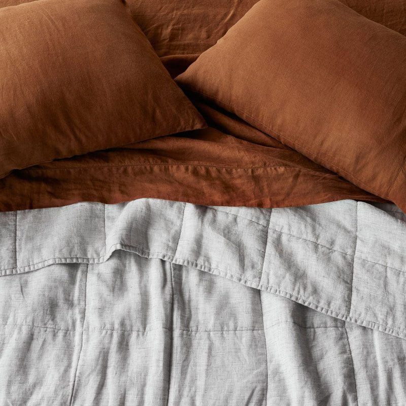 Overhead of Grey Striped linen quilt and sienna sheet set, graphite-thin-stripe
