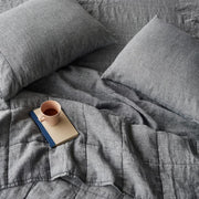 Overhead of indigo chambray linen quilt and sheet set, indigo-chambray