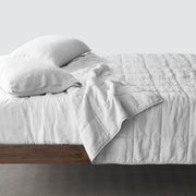 Side of bed with light grey stonewashed linen quilt, light-grey