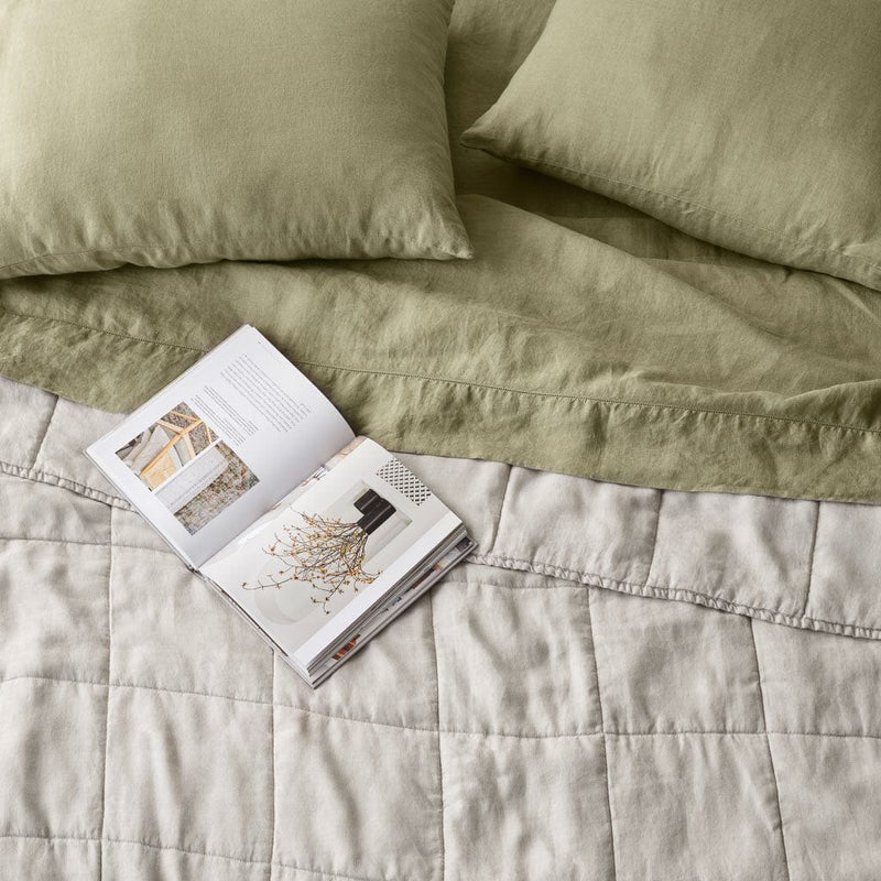 Overhead of sand linen quilt and sage green sheet set, solid-sand