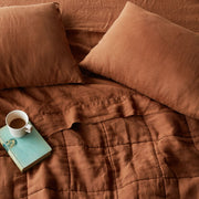 Overhead of sienna linen quilt and sheet set, sienna