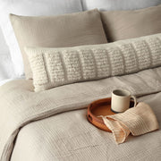 Ecru textured woven lumbar on bed, ecru
