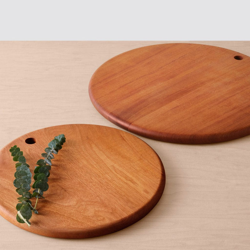 2 mahogany serving boards lying on counter with greenery, mahogany
