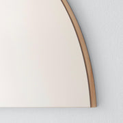 Close up of corner of half moon mirror in bronze